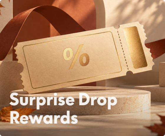 Golden ticket with a percentage symbol on a black and gold podium, surrounded by wrapped gift boxes and blue ribbons, promoting "Surprise Drop Rewards".