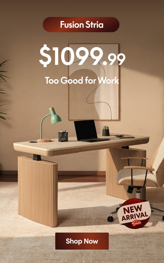Modern beige wood desk with ribbed panel design, paired with a cushioned swivel chair, green desk lamp, and decor. Price: $1099.99.