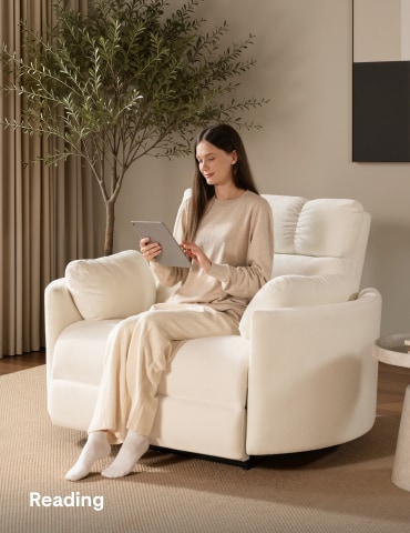 Woman reading while relaxing on an oversized power recliner chair in a cozy living room