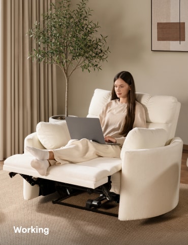 Woman working on a laptop while sitting comfortably on an oversized power recliner chair