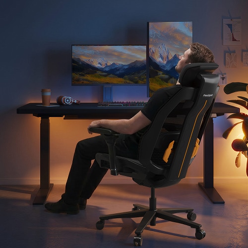 A man reclining to relax on the Wingo chair in a dimly lit gaming setup