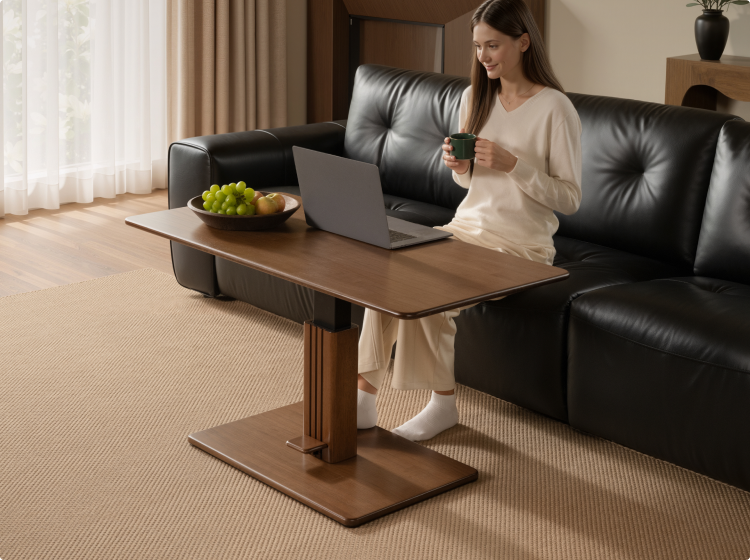 Woman using a laptop at the raised height-adjustable coffee table beside a sofa