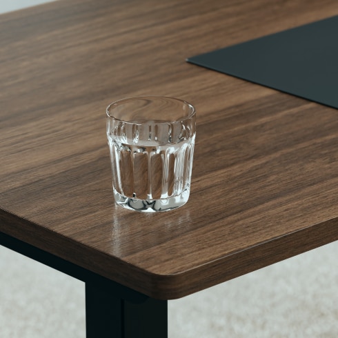 Tabletop appearance under cool light, restoring fine surface grain with glass cup reference