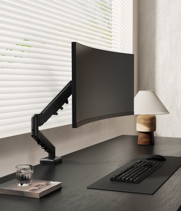 Monitor arm in use, curved wide screen office desk setup