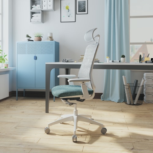 A modern office space featuring a stylish ergonomic chair, a desk, and a blue cabinet, with natural light streaming in through a window.